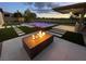 Inviting backyard with a modern fire pit, pool, and lounge chairs for relaxation and outdoor entertainment at 5 Clear Crossing Trl, Henderson, NV 89052