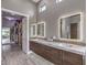 Bathroom with dual sinks, marble countertop, wood cabinets, and access to walk-in closet at 5 Clear Crossing Trl, Henderson, NV 89052