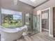 This luxurious bathroom features a soaking tub, glass shower, and a view of the beautifully landscaped yard at 5 Clear Crossing Trl, Henderson, NV 89052