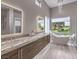 Modern bathroom showcases a soaking tub, dual sinks with marble countertops, and elegant lighting fixtures at 5 Clear Crossing Trl, Henderson, NV 89052