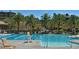 Community pool with lap lanes, palm trees, lounge chairs, umbrellas, and well-maintained landscaping at 5 Clear Crossing Trl, Henderson, NV 89052
