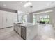 Modern kitchen features a quartz waterfall island, stainless steel appliances, and an open dining area at 5 Clear Crossing Trl, Henderson, NV 89052