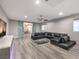 Bright living room with black sectional, sliding glass doors, and modern media console at 5 Clear Crossing Trl, Henderson, NV 89052