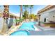 Backyard pool area showcases lush landscaping with palm trees, rock features, and a built-in barbeque at 5 Red Fawn Ct, Henderson, NV 89074