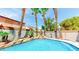 Sparkling pool with rock waterfall, lush tropical landscaping, and privacy in backyard at 5 Red Fawn Ct, Henderson, NV 89074