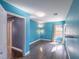 Bright blue bedroom with gray wood floors, a window with blinds and curtains, and a small table at 5031 Naff Ridge Dr, Las Vegas, NV 89131