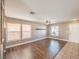 Bright living room with wood floors, large windows, a ceiling fan, and built-in shelving at 5031 Naff Ridge Dr, Las Vegas, NV 89131