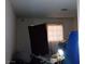 A messy bedroom with a window covered by a dark curtain, and various items scattered around at 5324 Del Monte Ave, Las Vegas, NV 89146