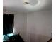 An interior room with a window covered with a dark curtain, white walls, and dark floors at 5324 Del Monte Ave, Las Vegas, NV 89146