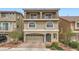Charming three-story home features a balcony, arched windows, neutral stucco, and a two car garage at 5340 Kennedy Hill Ave, Las Vegas, NV 89139