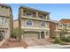 Charming three-story home with a balcony, arched windows, and a brick paved driveway at 5340 Kennedy Hill Ave, Las Vegas, NV 89139