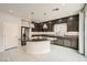 This kitchen features stainless appliances, dark wood cabinets, a granite island and white tile floors at 5340 Kennedy Hill Ave, Las Vegas, NV 89139