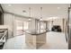 Kitchen showcasing island, dark cabinets, stainless steel appliances, and light wood-look floors at 5340 Kennedy Hill Ave, Las Vegas, NV 89139