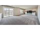 Large living room with a sliding glass door, neutral paint, and plush carpeting at 5340 Kennedy Hill Ave, Las Vegas, NV 89139