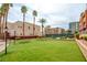 Complex common area featuring a vibrant green lawn, palm trees, and neatly trimmed bushes at 55 E Agate Ave # 309, Las Vegas, NV 89123
