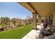 Covered patio with seating, turf grass lawn, and serene landscaping in the backyard at 5635 E La Campana Dr, Pahrump, NV 89061