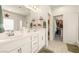 Bright bathroom featuring double sinks, white cabinets, and a doorway to a walk-in closet at 5635 E La Campana Dr, Pahrump, NV 89061