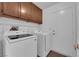 Laundry room with washer, dryer, cabinets, shelf and access to exterior at 6150 W Brooks Ave, Las Vegas, NV 89108