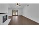 Spacious living room featuring a brick fireplace, wood-style flooring, and access to the backyard at 6150 W Brooks Ave, Las Vegas, NV 89108