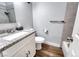 Stylish bathroom featuring a granite countertop, white vanity, and modern fixtures over wood flooring at 6232 Bristol Way, Las Vegas, NV 89107