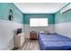 Bedroom with a blue accent wall, TV, and wooden floors at 6232 Bristol Way, Las Vegas, NV 89107