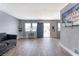Bright living room with wood floors, grey walls, TV, and an open entrance door allowing natural light at 6232 Bristol Way, Las Vegas, NV 89107