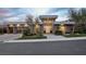 Modern home exterior featuring a three-car garage, lush landscaping, and sleek architectural lines at 667 Palisade Rim Dr, Henderson, NV 89012