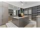 Large walk-in closet with custom shelving, mirrored doors, and a central island at 667 Palisade Rim Dr, Henderson, NV 89012