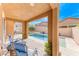 Covered patio with seating overlooking a refreshing pool and landscaped backyard at 689 Silver Pearl St, Henderson, NV 89002