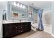Bathroom featuring blue walls, a double sink, a bathtub with shower and wood-look tile flooring at 689 Silver Pearl St, Henderson, NV 89002