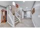 Elegant foyer featuring a grand staircase, light gray walls, and wood-look tile flooring at 689 Silver Pearl St, Henderson, NV 89002