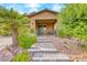 Quaint front porch with seating, complemented by lush landscaping and stone accents at 689 Silver Pearl St, Henderson, NV 89002