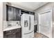Modern kitchen with stainless refrigerator, dark cabinetry, and stone backsplash at 689 Silver Pearl St, Henderson, NV 89002