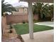Lush backyard featuring an in-ground pool and rock waterfall feature surrounded by green artificial turf at 7073 Seabirds Pl, North Las Vegas, NV 89084