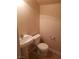 Compact half-bath with pedestal sink, ceramic tile floor, and modern toilet, offering essential functionality at 7073 Seabirds Pl, North Las Vegas, NV 89084