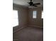 This bedroom features plush carpet, a ceiling fan, and a natural light from two windows with blinds at 7073 Seabirds Pl, North Las Vegas, NV 89084