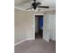 Bedroom featuring soft carpet, a ceiling fan, and a door to another room with a brightly painted wall at 7073 Seabirds Pl, North Las Vegas, NV 89084