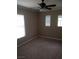 This bedroom features plush carpet, a ceiling fan, and natural light from two windows with adjustable blinds at 7073 Seabirds Pl, North Las Vegas, NV 89084