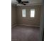 This bedroom features plush carpet, a ceiling fan, and a natural light from two windows with blinds at 7073 Seabirds Pl, North Las Vegas, NV 89084