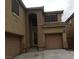 Tan two-story home featuring shutters, an attached two-car garage, and a concrete driveway at 7073 Seabirds Pl, North Las Vegas, NV 89084