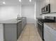 Kitchen with tile flooring, granite countertops, stainless steel appliances, and gray cabinetry at 7452 Sunray Point St, North Las Vegas, NV 89084