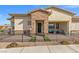 Charming home exterior with a stone facade, covered porch, and a decorative black metal fence at 746 Purple Knoll Walk, Henderson, NV 89011