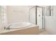 Bathroom showcasing a soaking tub, separate shower, and glass block window providing privacy and natural light at 7568 Shadow Estates Way, Las Vegas, NV 89113