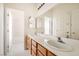 Well-lit bathroom boasts dual sinks and a large mirror, offering ample space and functionality at 7568 Shadow Estates Way, Las Vegas, NV 89113