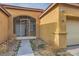 Close up of home entryway with decorative metal gate and beige stucco exterior at 7568 Shadow Estates Way, Las Vegas, NV 89113