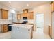 Bright kitchen with wooden cabinets, an island, and access to other rooms, ideal for culinary creations at 7568 Shadow Estates Way, Las Vegas, NV 89113