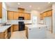 Well-lit kitchen with wooden cabinets, white countertops, and modern black appliances, ready for cooking at 7568 Shadow Estates Way, Las Vegas, NV 89113