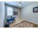 Well-lit bedroom featuring a ceiling fan, comfortable chairs, and carpet at 8036 Literature Ct, Las Vegas, NV 89113