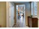 Inviting hallway with wood-look flooring, leading to the main living area, with shuttered window at 8036 Literature Ct, Las Vegas, NV 89113