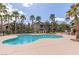 A refreshing community pool surrounded by palm trees with lounge chairs for residents at 8250 N Grand Canyon Dr # 1084, Las Vegas, NV 89166